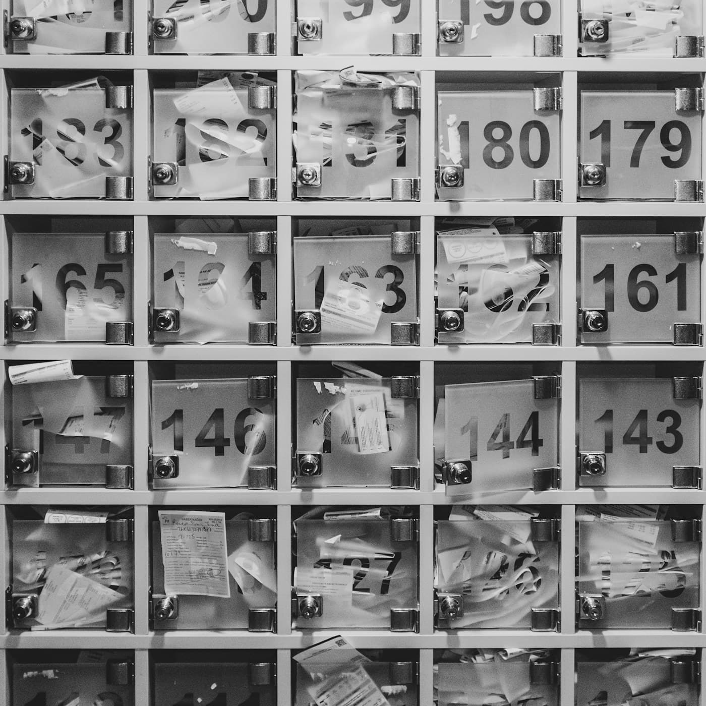 Numbered pigeonholes in a grid, some stuffed with papers.